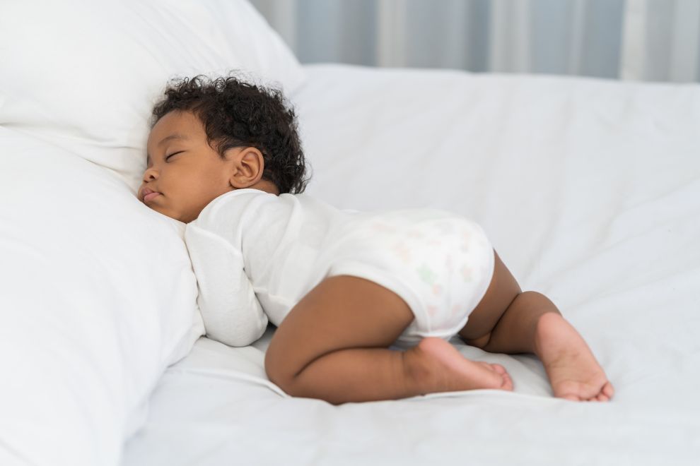 black baby sleeping on bed
